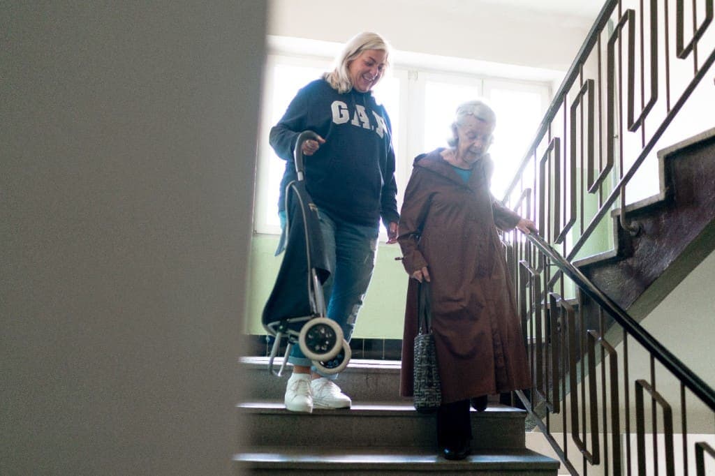 Zwei Frauen gehen gemeinsam eine Treppe hinunter